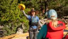 female river guide holding up a whitewater helmet