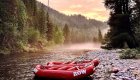 Two red ROW branded boats tied off to the shore at sunset