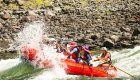 Group of guests on a raft getting splashed in the middle of a rapid