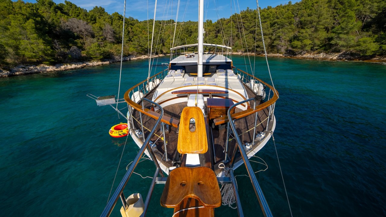 A bow view of a yacht anchored in a secluded bay in Croatia.