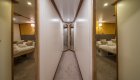 The hallway of a luxury yacht leading to multiple cabins.